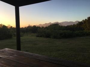 Blick auf ein Feld von einer Veranda in der Unterkunft Pura Vida Forest Cabin in Witelsbos