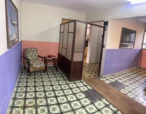 an empty room with a door and a chair at El Pueblito in Cochabamba