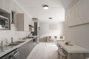 a white kitchen with a sink and a table at Tranquil Zen Oasis in Midrand: The Perfect Retreat in Midrand
