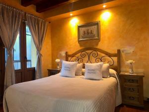 a bedroom with a white bed with two pillows at Hostal segovia adults only in Segovia