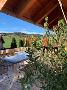 eine Terrasse mit einem Tisch, Stühlen und einem Zaun in der Unterkunft Chalet Buron 7 in Kaufbeuren