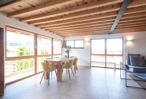 a dining room with a table and chairs and windows at Chalet Buron 7 in Kaufbeuren