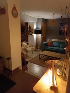 a living room with a blue couch and a table at LE RUCHER DE LA VIGNETTE in Le Grand-Bornand