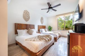 twee bedden in een kamer met een tv bij Tulum Village Condominium in Tulum