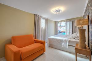 ロス・クリスティアーノスにあるVilla 4bed private pool en Los Cristianosの窓のあるベッドルーム(オレンジ色の椅子付)