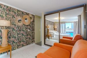 ロス・クリスティアーノスにあるVilla 4bed private pool en Los Cristianosのリビングルーム(オレンジ色のソファ付)、ベッドルーム1室が備わります。