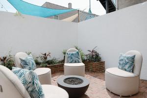 a patio with three chairs with blue and white pillows at 29 South by Mira-Mar in Wilmington