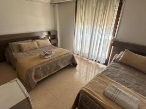 pokój hotelowy z 2 łóżkami i oknem w obiekcie Hotel Lujan w mieście Piriápolis