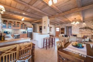 a large kitchen and living room with wooden ceilings at Astarte Villas - Diva Affluence with Private Pool in Koríthion