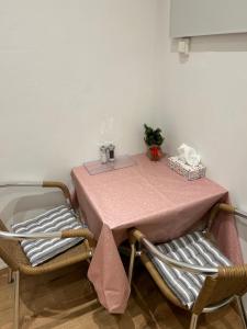 ウィーンにあるVienna Prater Apartmentのピンクのテーブルクロスと椅子2脚付きのテーブル
