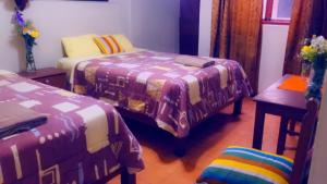 Zimmer mit 2 Betten, einem Tisch und einem Stuhl in der Unterkunft HOTEL VISTA HERMOSA in Trujillo