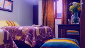 1 Schlafzimmer mit 2 Betten, einem Tisch und einem Fenster in der Unterkunft HOTEL VISTA HERMOSA in Trujillo