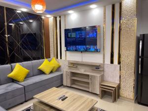 sala de estar con sofá y TV en شركة مسايا لشقق المفروشة, en Irbid
