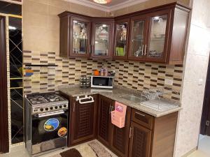a kitchen with a stove and a microwave at شركة مسايا لشقق المفروشة in Irbid