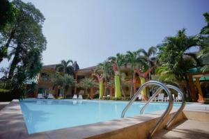 ein Pool mit Palmen und ein Gebäude in der Unterkunft Coconut Beach Resort, Koh Chang in Ko Chang