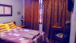 Schlafzimmer mit einem Bett und einem Fenster mit Vorhängen in der Unterkunft HOTEL VISTA HERMOSA in Trujillo