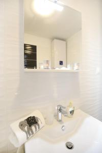 uma casa de banho branca com um lavatório e um espelho em Apartment Flowers em Zadar