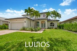 una casa grande con palmeras en un patio en Glamour Villa - 5BR, Heated Pool, Game Haven L23, en Miami