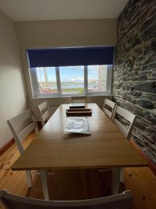ein Esstisch mit Stühlen und ein großes Fenster in der Unterkunft Lovely apartment overlooking the harbour and bay in Ardglass