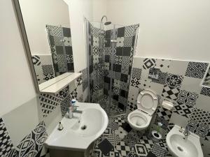 een badkamer met een wastafel, een toilet en een spiegel bij Suite Della Porta in Napels +33 foto's
