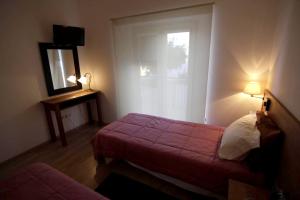 a bedroom with a bed and a mirror and a window at Luxurious House in Corte de Pao with Private Pool in Corte de Pão e Água