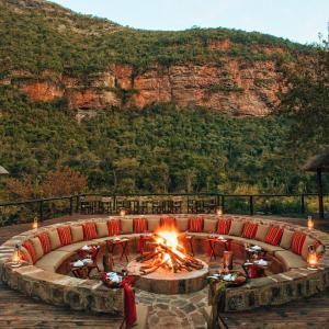 a fire pit with a couch in front of a mountain at Duma Manzi Eco Lodge & Spa in Richmond
