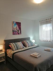 1 dormitorio con 1 cama con 2 toallas en Sobe pri Roži, en Postojna