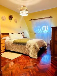 a bedroom with a bed and a wooden floor at La Casa de Carmen in Malpica