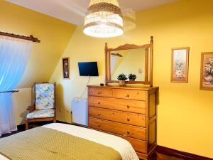 a bedroom with a bed and a dresser and a mirror at La Casa de Carmen in Malpica