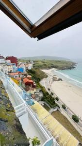 a view of a beach and the ocean from a building at La Casa de Carmen in Malpica