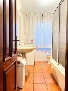 a bathroom with a sink and a toilet and a window at La Casa de Carmen in Malpica