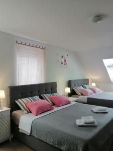 2 camas con almohadas rosas en un dormitorio en Sobe pri Roži en Postojna