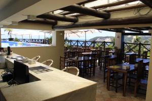 un restaurante con mesas y sillas y una piscina en Sunbrazil Hotel - Antigo Hotel Terra Brasilis en Natal