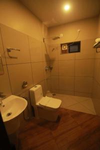 a bathroom with a toilet and a sink at CeeCee Grand Resort in Vagamon