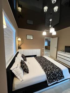 ママイアにあるSas 1 Luxury Apartmentsのベッドルーム1室(大型ベッド1台、白黒の枕付)