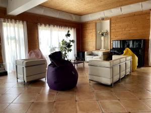 a living room with two white chairs and a couch at La Maison Rose sur le Port in Saint-Louis-du-Rhône