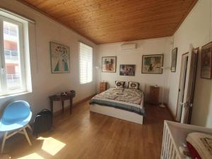 a bedroom with a bed and a wooden ceiling at La Maison Rose sur le Port in Saint-Louis-du-Rhône