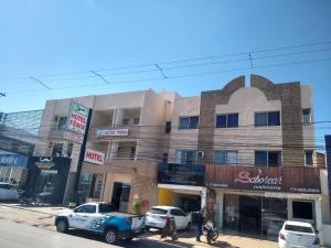 a building on a street with cars parked in front of it at Hotel Fênix in Barreiras