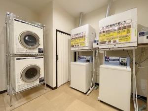 a laundry room with two washers and two machines at 釜石駅から徒歩5分ホテルマルエHotelMarue in Kamaishi