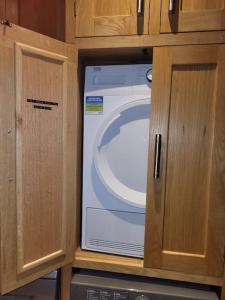 uma máquina de lavar e secar roupa sentada num armário em Ballure House em Sligo