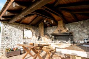 cocina de piedra con mesa y chimenea en Villa Alexandros - Four Seasons, en Patra