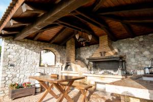 a stone kitchen with a table and a fireplace at Villa Alexandros - Four Seasons in Patra