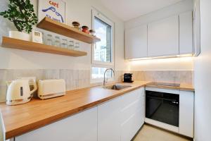a kitchen with white cabinets and a sink at Luxury Duplex by Les Maisons de Charloc Homes in Boulogne-Billancourt
