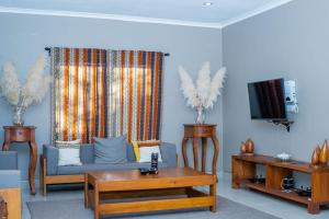 uma sala de estar com um sofá e uma televisão em Tulivu Kilimanjaro Retreat and Campsite em Moshi