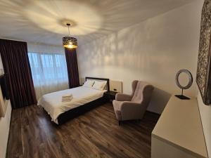 a hotel room with a bed and a chair at ArtMob Apartment Isaran in Braşov