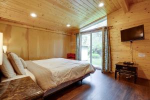 een slaapkamer met een bed en een flatscreen-tv bij Brookings Home with Deck, half Mi to Harris Beach! in Brookings