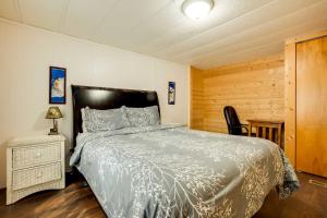 1 dormitorio con 1 cama y pared de madera en Brookings Home with Deck, half Mi to Harris Beach! en Brookings