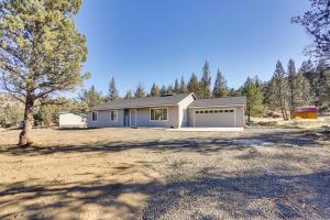 a house with a garage in the middle of a field at Terrebonne Home Steps to Deschutes River! in Terrebonne