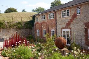 a garden in front of a brick building at Bishopstrow Hotel and Spa - Small Luxury Hotels of the World in Warminster