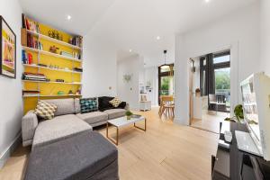 ein Wohnzimmer mit einem Sofa und einem Tisch in der Unterkunft Trendy 2 bed Flat in Greenwich with Car Parking in London
